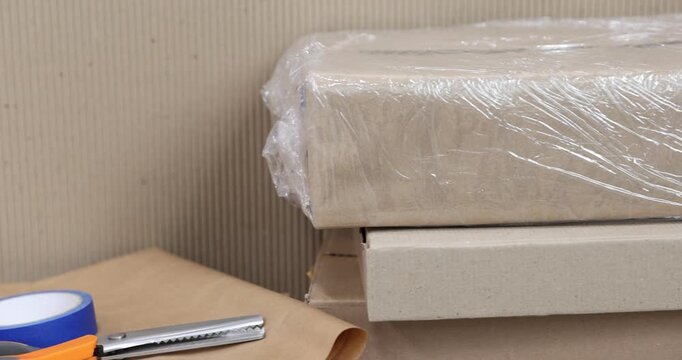 Different packaging materials and scissors, closeup. Camera moving left