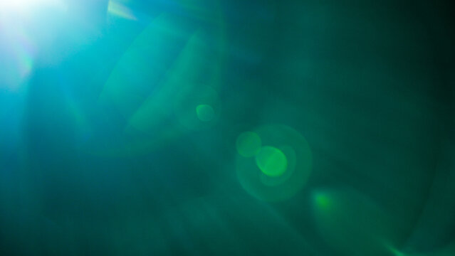 An ethereal abstract background of shimmering teal and green light, with soft bokeh circles and lens flares, creating a dreamlike or magical atmosphere.
