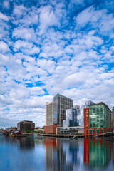 Obraz premium South Boston Waterfront skyline with skyscrapers, ships, and cumulus clouds in the blue sky in Boston, Massachusetts, USA