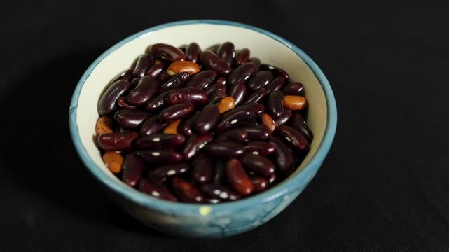 protein rich red beans displayed in bowl isolated against black background