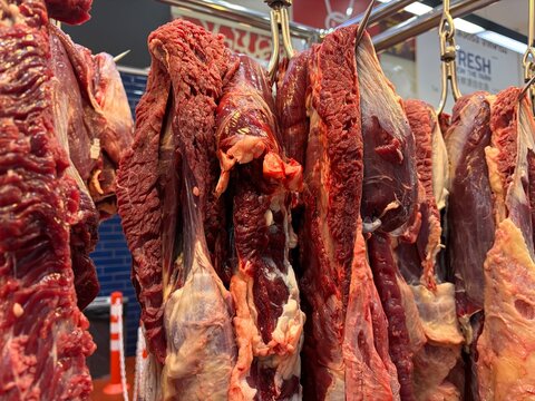 Fresh raw beef hanging at a traditional local wet market stall. Beef Brisket.