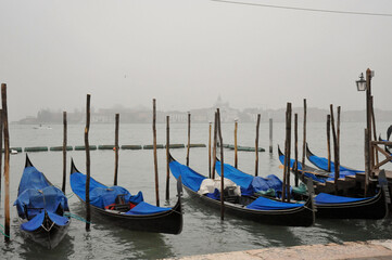 Traditional Gondolas Moored on a Foggy Venice Canal © Jaime