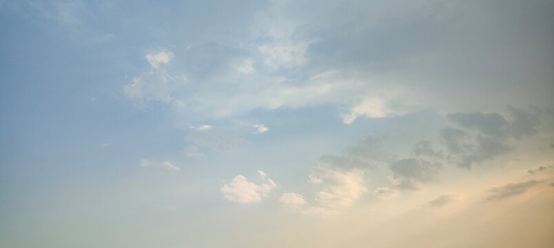 Gradient Pale Blue to Warm Cream Twilight Sky with Soft Shaded Cumulus Cloud Formations