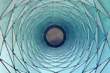 Fototapeta premium Abstract geometric pattern of a modern building's glass facade looking up