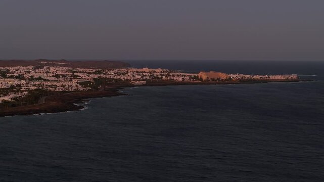 Costa Teguise resort town featuring white buildings along the Atlantic Ocean coast at sunset