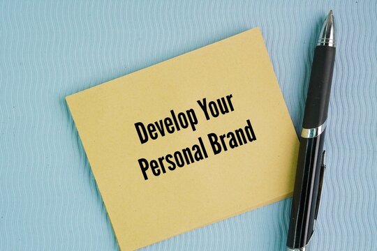 Pen and paper with the words Develop Your Personal Brand. proactively and strategically shaping how the world perceives your professional expertise, skills, and values.