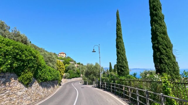 Winding Coastal Road with Lush Greenery and Sea Views in Italy