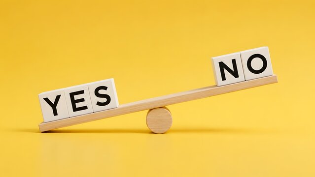 Wooden blocks with yes and no words balancing on a seesaw illustrating business decision making