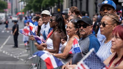 Obraz premium People celebrate on the street holding flags during a parade in a city on a sunny day in summer