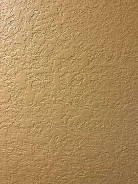 Detailed Close-up of Knockdown Drywall Texture for Renovations. Yellow Wall to Use as Background with Knockdown Finish. Cream texture wall background.