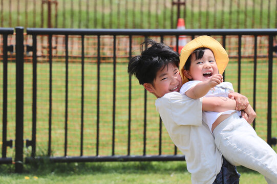 笑顔でじゃれ合う小学生と幼児の兄弟