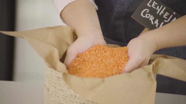 Lenteja coral seca, legumbre para alimentaci&oacute;n saludable y prote&iacute;na vegetal, mano sosteniendo y dejando caer granos en c&aacute;mara lenta (Slow Motion), Footage cocina, comida