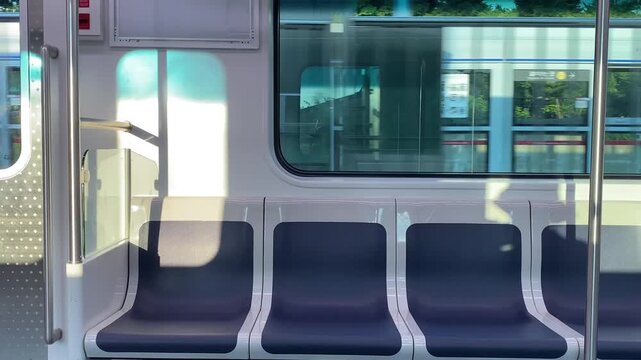 Empty seats inside a modern clean subway train cabin with window reflection, South Korea