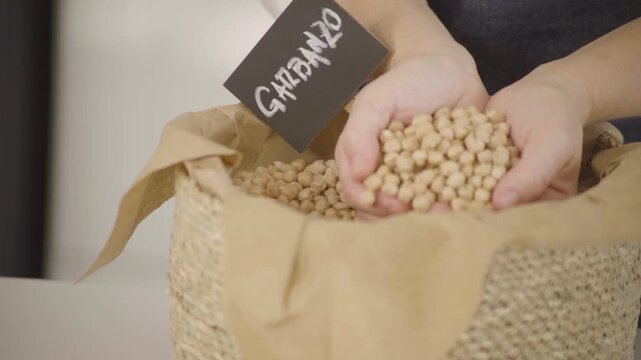 Garbanzos secos, legumbre para alimentaci&oacute;n saludable y prote&iacute;na vegetal, mano sosteniendo y dejando caer granos en c&aacute;mara lenta (Slow Motion), Footage cocina, comida