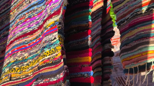 Close up of Egyptian hand made cotton striped carpets with colorful woven texture under the sunlight 
