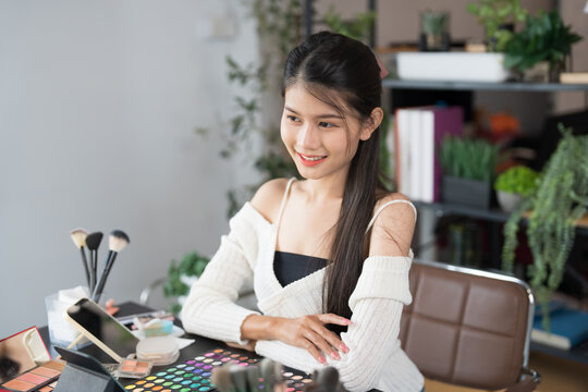 Asia woman beauty influencer makeup artist vlogger live streaming makeup tutorial on smartphone for social media