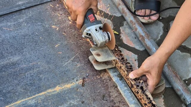 Worker Cutting Rusty Iron Gate with Angle Grinder Tool Creating Bright Sparks Outdoor