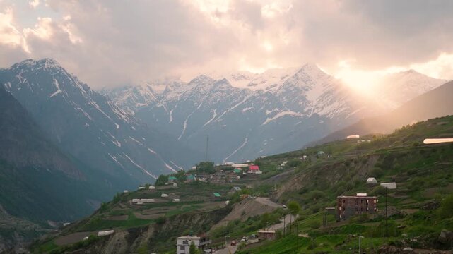 4K Landscape shot of orange sun rays through the clouds during the sunset as seen from Khangsar village in Lahaul and Spiti district, Himachal Pradesh, India. Scenic sunset background.