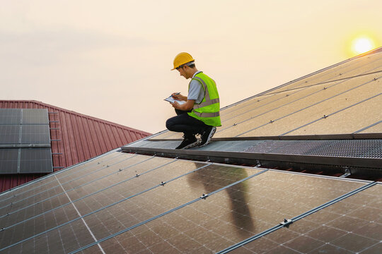 Solar technician inspects panels with notebook