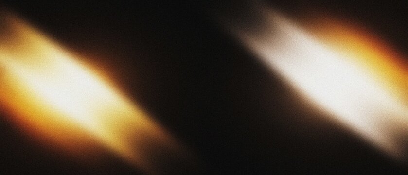 Diagonal light streaks with warm and cool tones against a dark background abstract texture