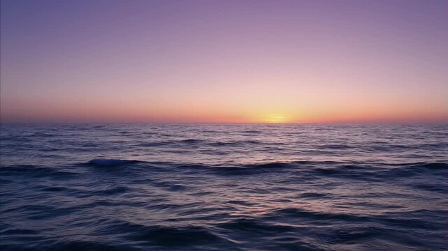 Vast ocean water surface during colorful dusk sky moment, horizontal view of tranquil seascape at sunset time, August 23 International Day for the Remembrance of the Slave Trade and its Abolition