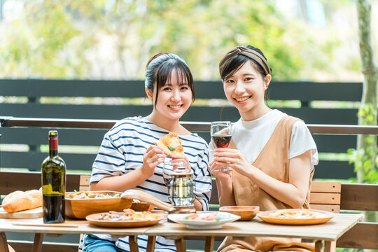 Young women enjoying meals on the terrace, barbecues, home parties, and glamping with friends.