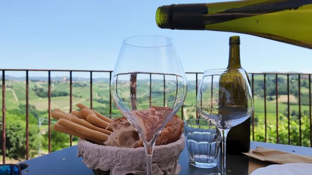 White Wine Pouring into Glass on Terrace Overlooking Italian Vineyards