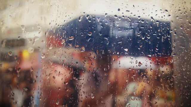 Rainy day street scene through window with raindrops