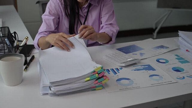 Business professional analyzing financial documents and data charts at office desk