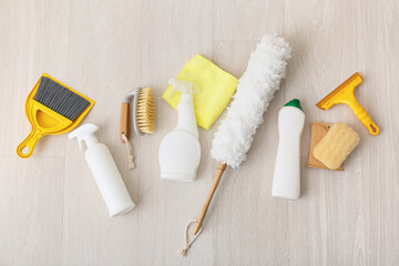 Obraz premium Home cleaning supplies and tools for housekeeping, top view of various household products on wooden floor