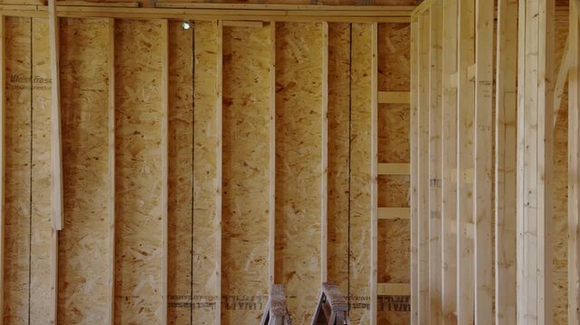 Wood framing inside a new construction of residential house with unfinished walls and structural beams