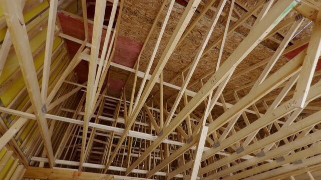 Wood framing a new residential house under construction with unfinished structural support beams