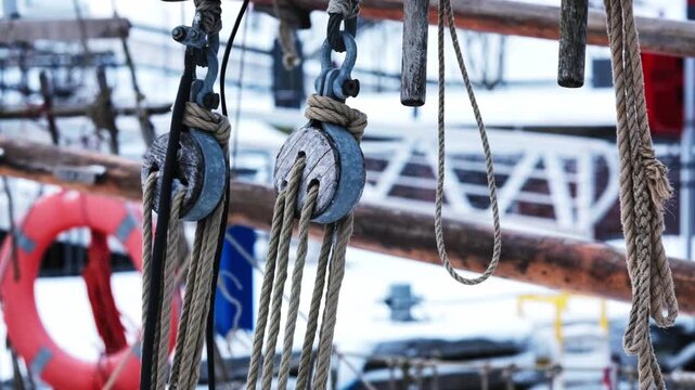 Wooden blocks, lines and shackles on a boat swaying in the breeze