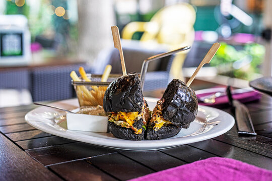 A black Krabby Patty cut in half on a plate