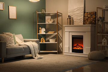 Obraz premium Cozy living room interior with electric fireplace, comfortable sofa, and decorative shelving for home comfort
