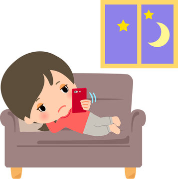 スマホをいじって夜更かしする若い女性