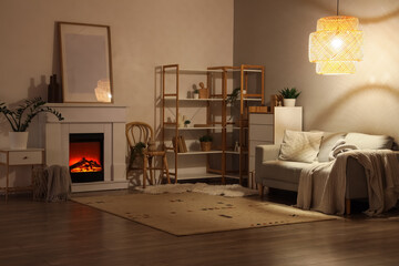 Obraz premium Cozy living room interior with electric fireplace, comfortable sofa, and warm lighting for relaxation