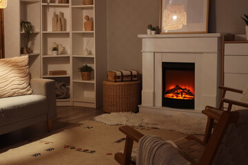 Obraz premium Cozy living room interior with electric fireplace, comfortable sofa, and decorative bookshelves for home comfort
