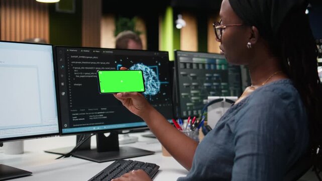 Isolated screen smartphone used by admin in office working to fix bugs in artificial intelligence system. Employee in tech startup using chroma key mockup mobile phone to watch videos.
