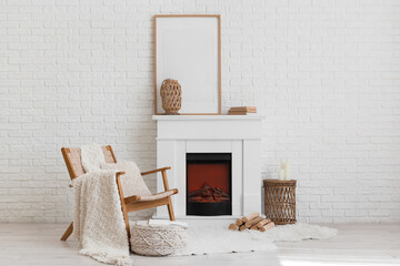 Obraz premium Cozy living room interior with white brick wall, fireplace, wooden chair, and blank picture frame for home decor mockup