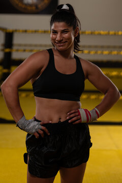 Confident Female Boxer Athlete Smiling in Boxing Gym After Training Session With Hand Wraps