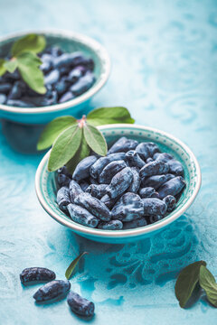 Organic honeysuckle (honeyberry) in a blue bowl on table