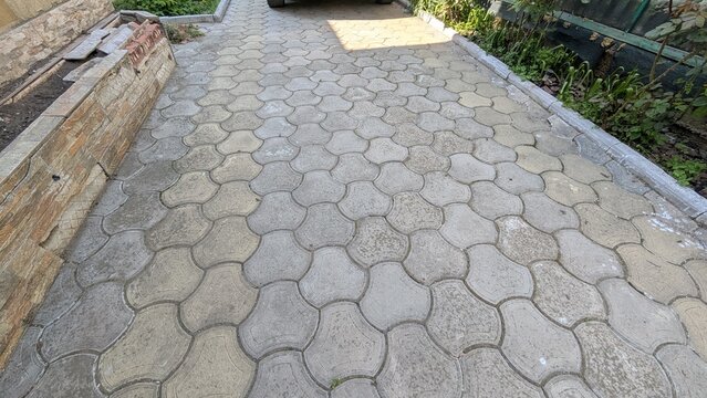 Outdoor stone paver walkway in a yard with garden greenery