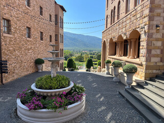 Naklejka premium Mediterranean Style Courtyard with Stone Fountain and Mountain View