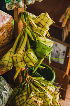 Bunches of fresh green ketupat woven palm leaf pouches at market