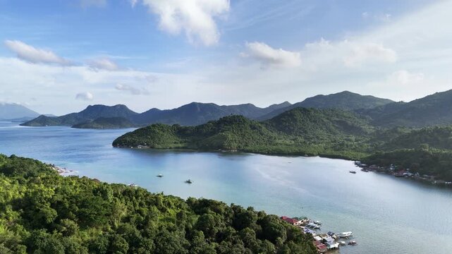 Aerial drone view of Liminangcong Port, revealing stilt houses and coastal housing along a tropical seascape, Philippines
