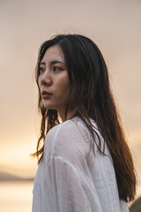 Fototapeta premium 夕暮れの海にいる女性