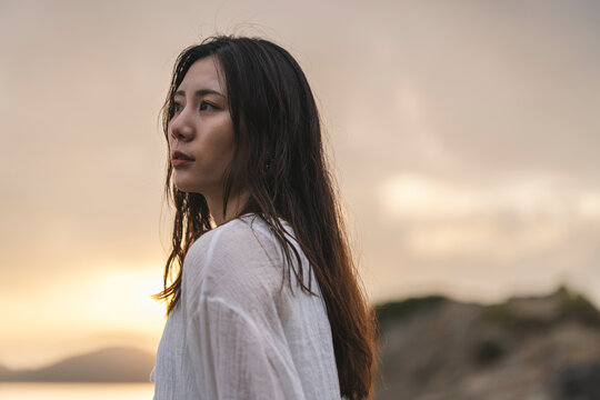 夕暮れの海にいる女性