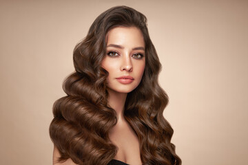Naklejka premium Brunette girl with perfect makeup. Smiling beautiful model woman with long curly hairstyle. Care and beauty hair products.