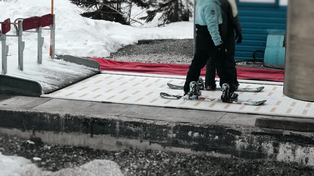 Skiers entering chairlift access gate at mountain resort. Winter sports infrastructure, ski pass control and alpine recreation concept.